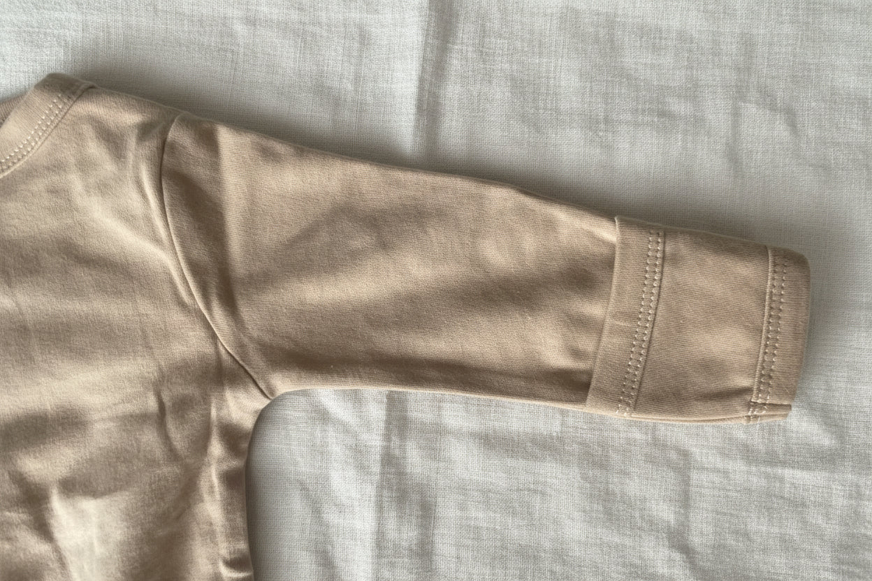 Détail de la manche et des coutures de la grenouillère bébé en coton OEKO-TEX